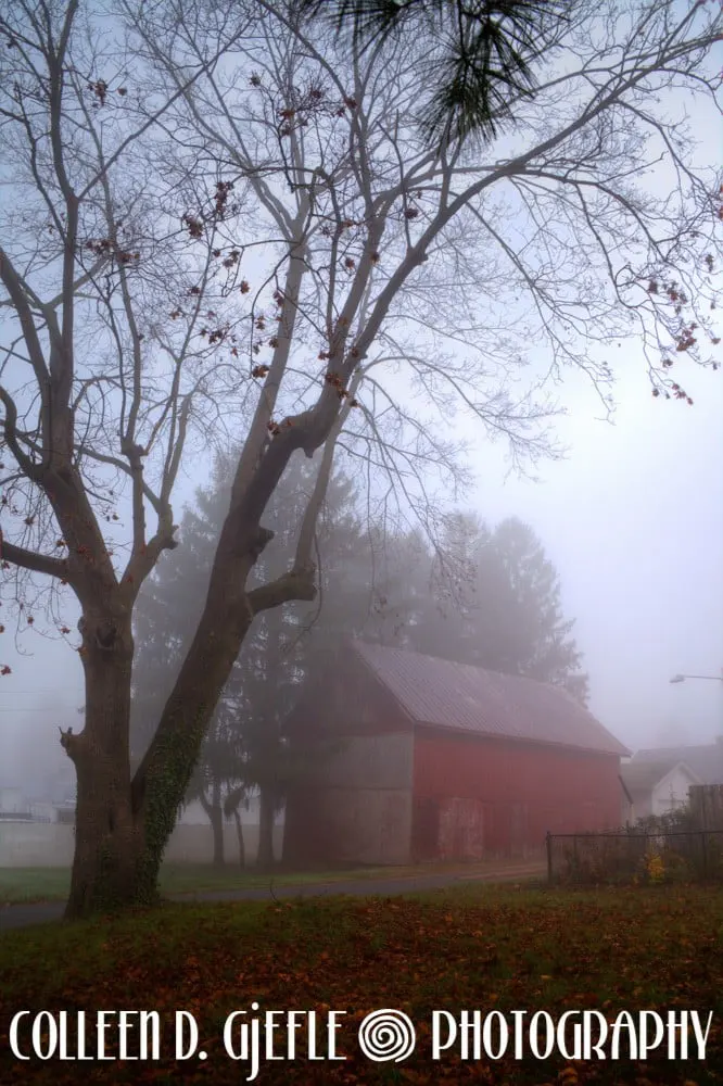 Old red barn in the fog